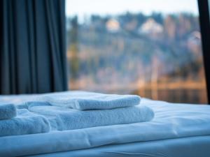uma pilha de toalhas sentadas numa cama com uma janela em Lake Igloo Ukkohalla em Hyrynsalmi