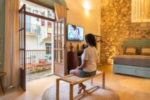 een vrouw die op een bank zit tv te kijken in een kamer bij Casa Túnez in Campeche