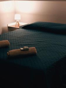 a bed with a green comforter and a table with a lamp at El Refugio - Hotel Mariscala in Mariscala