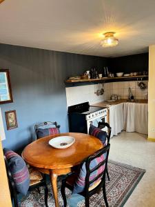 a kitchen with a wooden table with chairs and a stove at Bastide du Soldat in Abreschviller