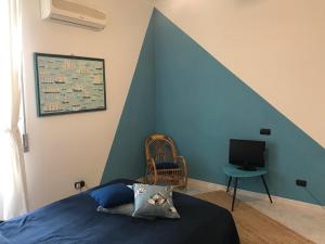 ein Schlafzimmer mit einer blauen Wand, einem Bett und einem TV in der Unterkunft Naples in the history 4M in Neapel