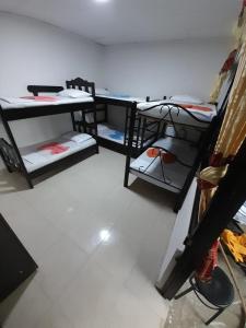 a room with three bunk beds in a room at Hostal Villa del Río Las Brisas in Villavieja