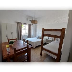 a bedroom with two bunk beds and a table at Hotel Are Pora in Gualeguaychú