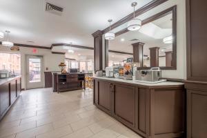 a kitchen with a counter with a sink and a mirror at Red Roof Inn PLUS+ & Suites Knoxville West - Cedar Bluff in Knoxville