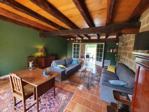 un soggiorno con divano e tavolo di Maison d'amis du Manoir de Saint-Bazile a Saint-Bazile-de-Meyssac