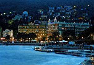 a city at night with a river and buildings at Apartment Silva in Opatija