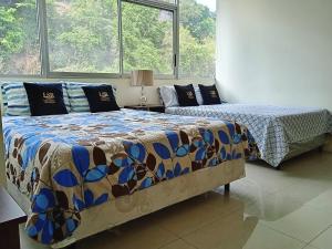 two beds in a room with two windows at Apartments Puerto Santa Ana in Guayaquil +58 photos