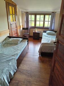 sypialnia z dwoma łóżkami i oknem w obiekcie Oberża KNIEJÓWKA w mieście Załom