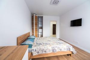 a bedroom with a bed and a table at NEW Apartment on Zhasmynova Street 5b in Lviv