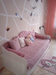 a bedroom with a pink bed and a chair at Apartments on Kashyns'koho Street 6 in Myrhorod