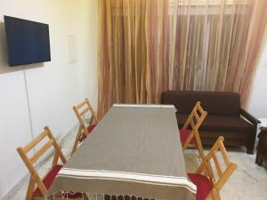 een kamer met een tafel en stoelen en een televisie bij Joli duplex à Hammamet dans résidence avec piscine in Hammamet
