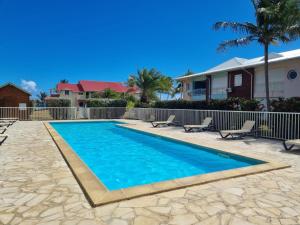 a swimming pool in a yard with chairs and a house at Crystal Beach, vue mer, accès direct plage et piscine, clim in Sèze