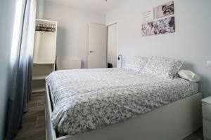 biała sypialnia z łóżkiem z białą kołdrą w obiekcie Alojamiento Turístico Las Cigüeñas w mieście Alcalá de Henares