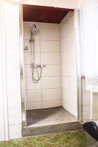 un bagno con doccia e piastrelle bianche di Alpenresorts Landeck a Landeck