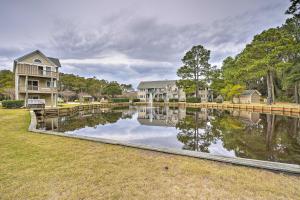 a house with a dock next to a body of water at Coastal Home with Community Pool Less Than 2 Miles to Beach! in Corolla