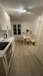 a white kitchen with a table and a dining room at Schwendi-Blueme in Heiligenschwendi