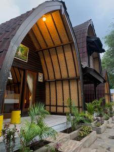 a house with a large window and plants in front of it at Gili Davidoff Bungalow in Gili Trawangan