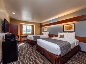 um quarto de hotel com duas camas e uma televisão em Microtel Inn and Suites Ocala em Ocala