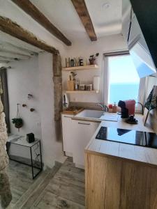 a kitchen with a sink and a window with the ocean at Mare è rocca in Bonifacio