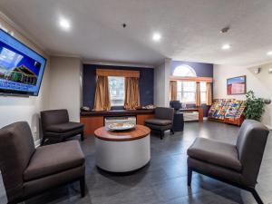 uma sala de espera com cadeiras, uma mesa e uma televisão em Microtel Inn and Suites Ocala em Ocala