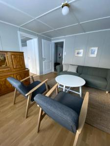 ein Wohnzimmer mit einem Sofa, einem Tisch und Stühlen in der Unterkunft Familienferien im Chalet Bärgli Kandersteg in Kandersteg