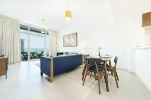 杜拜的住宿－Maison Privee - Superb 1BR apartment overlooking Zabeel Park and Dubai Frame，用餐室以及带桌椅的起居室。