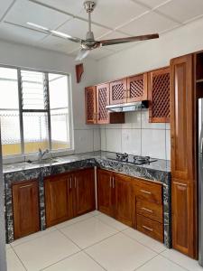 a kitchen with wooden cabinets and a ceiling fan at Hotel Malinche in Quepos