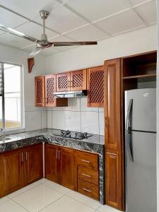 a kitchen with wooden cabinets and a stainless steel refrigerator at Hotel Malinche in Quepos