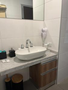 y baño con lavabo blanco y espejo. en Apartamento 2 Ambientes - Moderno totalmente Amoblado en Buenos Aires