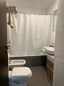 uma casa de banho com uma cortina de chuveiro branca e um WC. em Apartamento 2 Ambientes - Moderno totalmente Amoblado em Buenos Aires