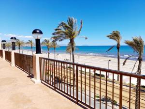 een balkon met uitzicht op het strand en de palmbomen bij Costa Blanca Holiday Rental AltaMar I in El Campello