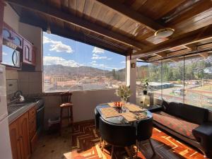 a kitchen with a table and a large window at Cusco Golden Perú Inn in Cusco