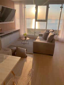 uma sala de estar com um sofá e vista para o oceano em 25 homeApart em Encarnación