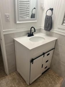 a white bathroom with a sink and a mirror at Casa de Taft in La Mesa