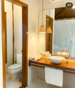 W łazience znajduje się umywalka, toaleta i lustro. w obiekcie Camauí Hotel w mieście Barra Grande