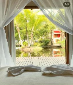 a bedroom with a window with a view of a garden at Camauí Hotel in Barra Grande