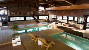 una piscina coperta in una casa con sedie e tavolo di Hotel Valgranda Wellness & Spa a Zoldo Alto