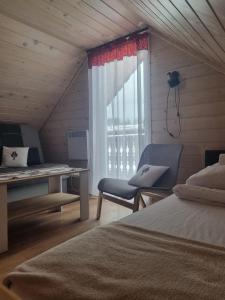 Schlafzimmer mit einem Bett, einem Schreibtisch und einem Fenster in der Unterkunft Domki na Zagroniu in Koninki