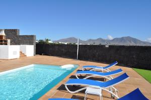 a swimming pool with two chairs and a swimming pool at Villa Esmeralda in Playa Blanca