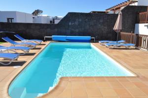 una piscina con tumbonas y una piscina en Villa Esmeralda en Playa Blanca
