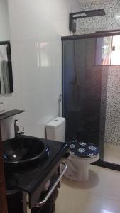 baño con lavabo negro y aseo en Apartamentos da praia, en Arraial do Cabo