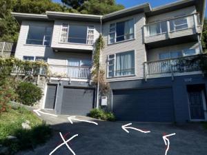 uma casa com garagem e alguns papagaios em frente em Quiet location with view and public transport em Wellington