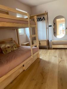 a bedroom with two bunk beds and a mirror at Piso reformado 5 pers, máx 4 adultos más niños, centro El Tarter - Grandvalira in El Tarter