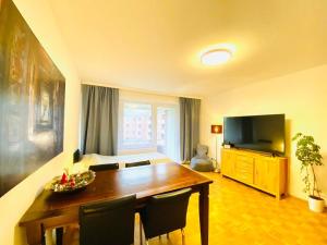 a living room with a wooden table and a television at HannoverMesseApartment 2 bedroom, Balcony with garden view in Hannover