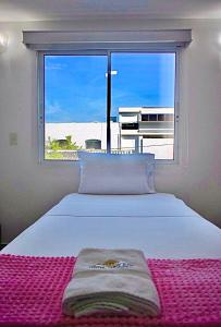 een slaapkamer met een bed en een groot raam bij Hotel Parque de los Novios Inn in Santa Marta