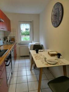 a kitchen with a table and a clock on the wall at Ferienwohnung Wanderparadies Neuwied-Heimbach in Neuwied +2 photos