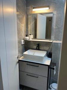 uma casa de banho com um lavatório branco e um espelho. em פסגת יובלים em Qiryat Shemona