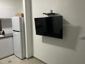 a flat screen tv hanging on a wall in a kitchen at פסגת יובלים in Qiryat Shemona +9 photos
