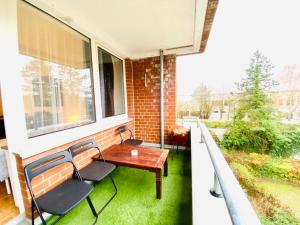 a balcony with a table and chairs and a window at HannoverMesseApartment 2 bedroom, Balcony with garden view in Hannover