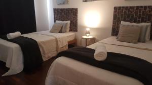 a room with two beds with white and black sheets at Pacific Spot San Miguel in Lima